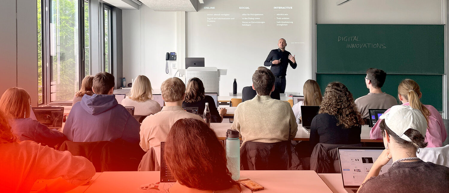 Studierende folgen einer Präsenzvorlesung zu digitalen Innovationen in einem hellen Hörsaal der Hochschule.