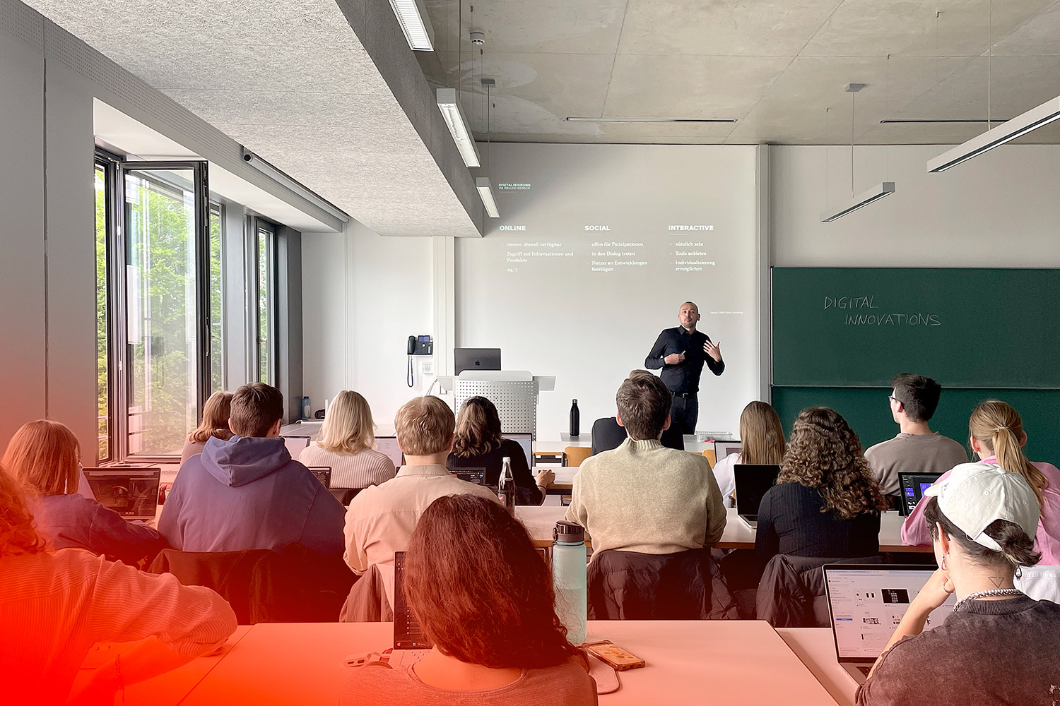 Studierende hören einem Vortrag über digitale Innovationen in einem hellen Hörsaal an der Hochschule zu.
